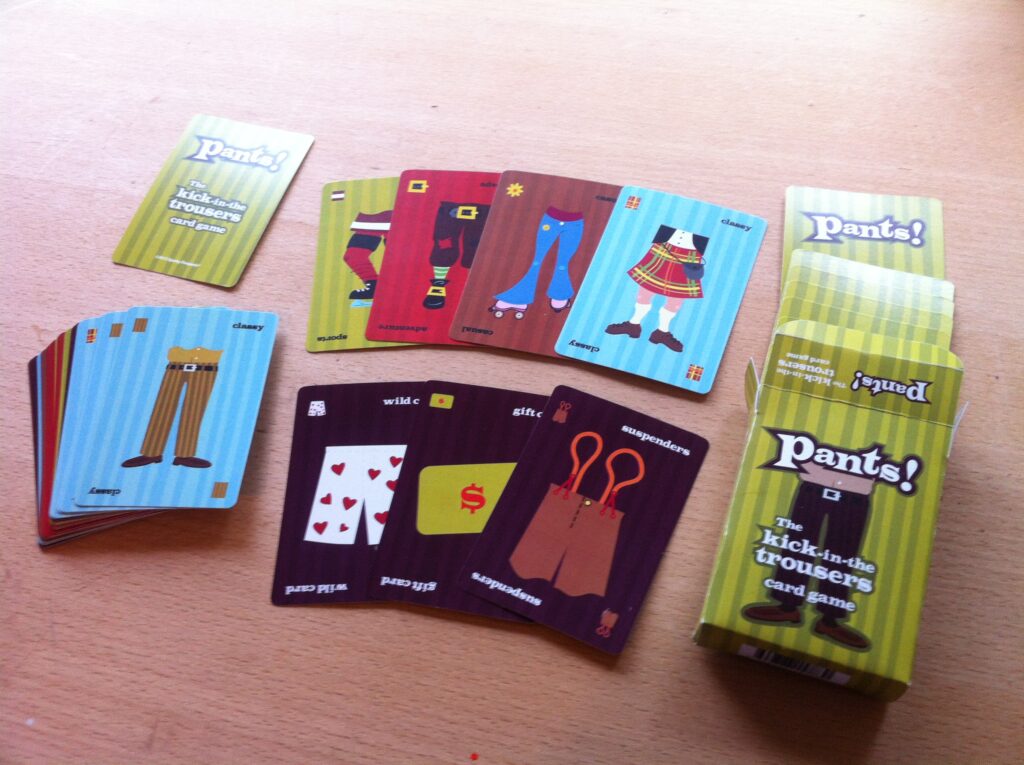 Pants! cards spread out on a table next to the box